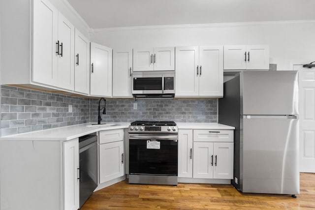 119 Clendenny Ave Unit 2R, Jersey City, NJ 07305 - kitchen with crown molding, a sink, light countertops, white cabinets, and stainless steel appliances