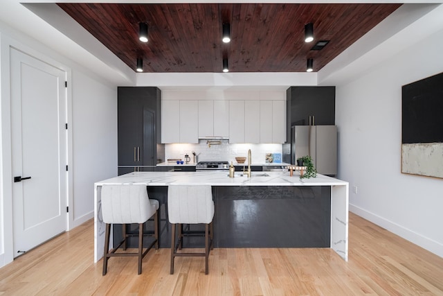 kitchen with freestanding refrigerator, a sink, wooden ceiling, modern cabinets, and tasteful backsplash