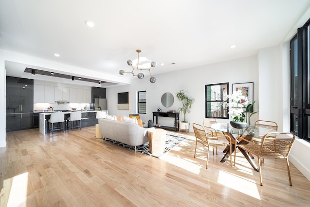 living room featuring recessed lighting, an inviting chandelier, and light wood-style floors