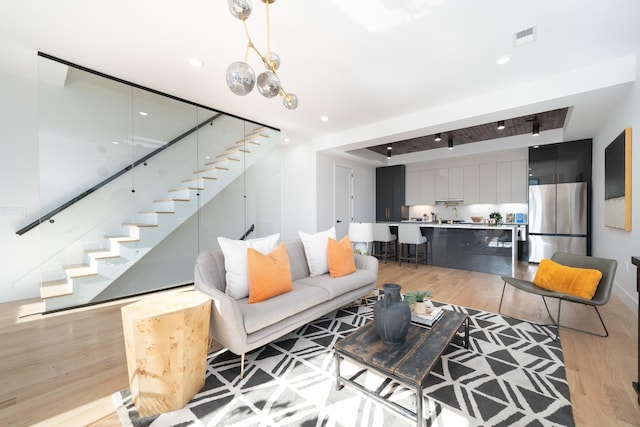 living room featuring stairway, recessed lighting, light wood-style flooring, and visible vents