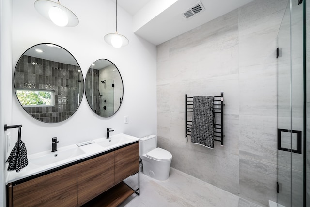 full bathroom featuring double vanity, visible vents, a shower stall, and a sink