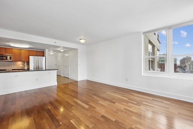 unfurnished living room featuring light hardwood / wood-style floors and sink