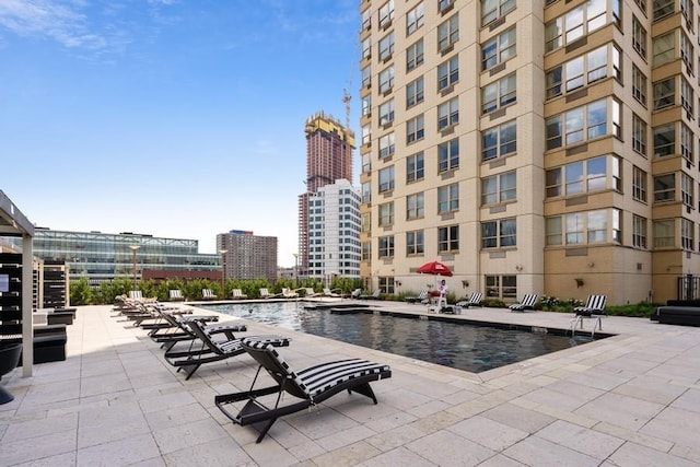 view of pool with a patio area and a water view