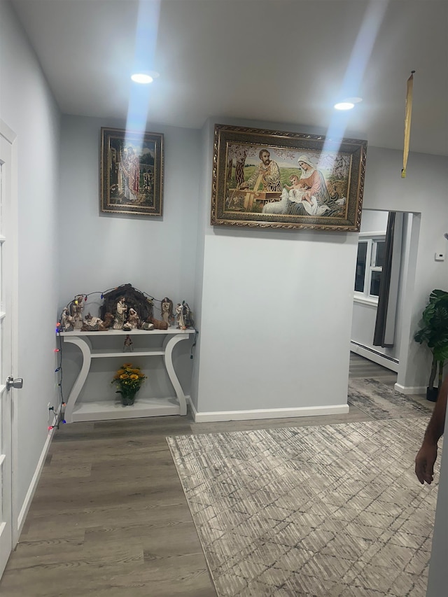 interior space with wood-type flooring and a baseboard heating unit