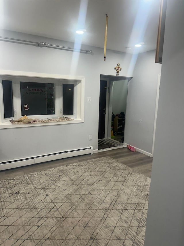 empty room featuring baseboard heating and light hardwood / wood-style flooring