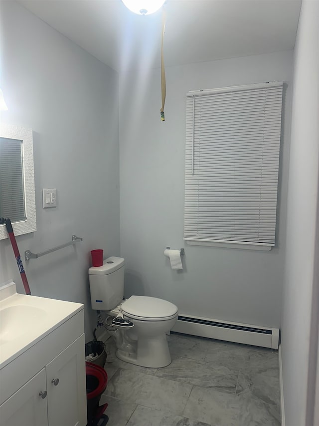 bathroom with baseboard heating, vanity, and toilet