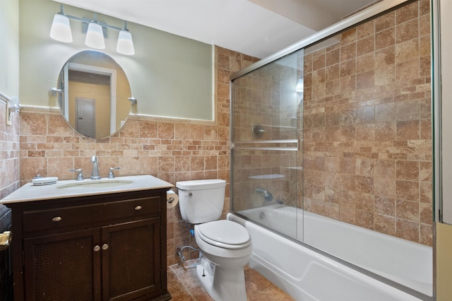 full bathroom with toilet, shower / bath combination with glass door, tile walls, vanity, and tile patterned flooring