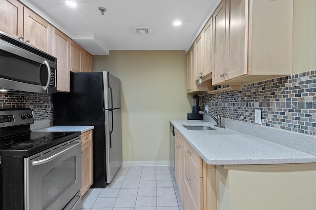 kitchen featuring sink, tasteful backsplash, light tile patterned floors, light brown cabinets, and appliances with stainless steel finishes