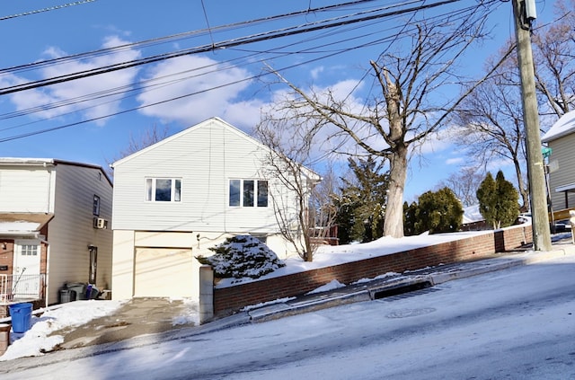 view of snowy exterior with a garage