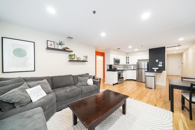 living area featuring light wood-style floors and recessed lighting