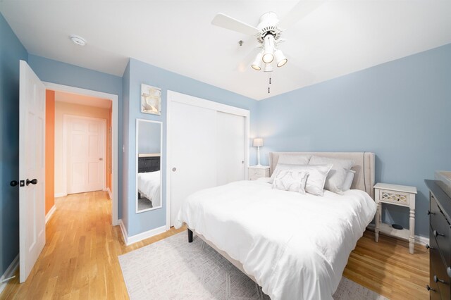 bedroom with light wood finished floors, baseboards, and a closet
