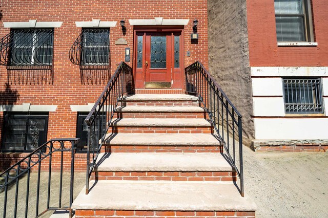 doorway to property featuring brick siding