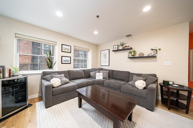 living room featuring beverage cooler, light wood-style floors, recessed lighting, and baseboards