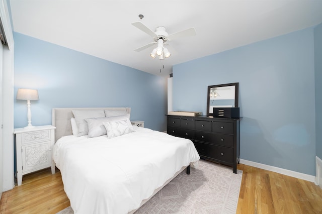 bedroom featuring light wood-style floors, baseboards, and ceiling fan