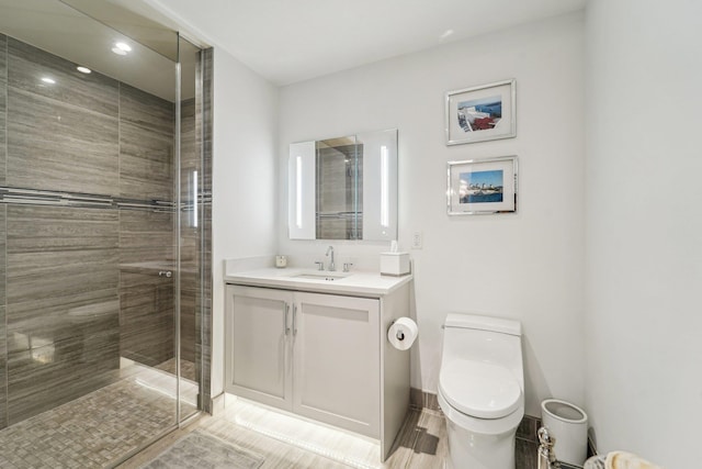 bathroom featuring vanity, toilet, and a shower with door