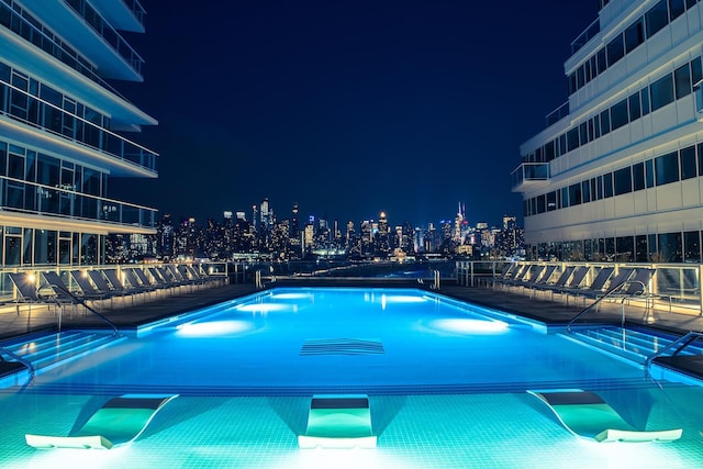 view of pool at twilight