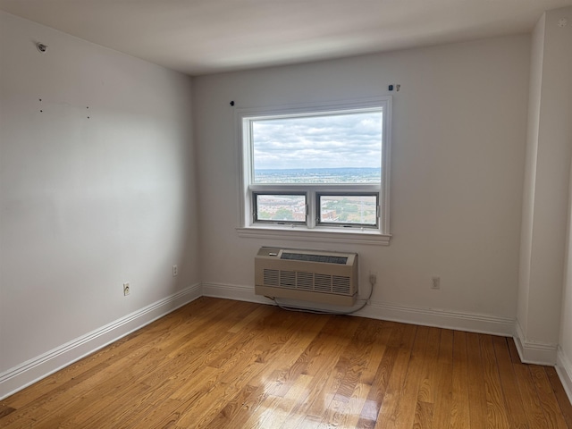 809 22nd St Unit 905, Union City, NJ 07087 - spare room with an AC wall unit, light wood-type flooring, and baseboards