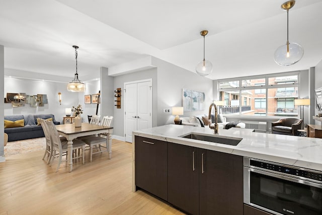 1400 Hudson St Unit 511, Hoboken, NJ 07030 - kitchen with open floor plan, light wood-type flooring, light stone countertops, and pendant lighting