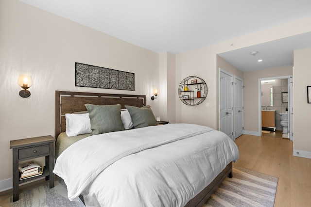 1400 Hudson St Unit 511, Hoboken, NJ 07030 - bedroom with light wood finished floors, ensuite bathroom, and recessed lighting