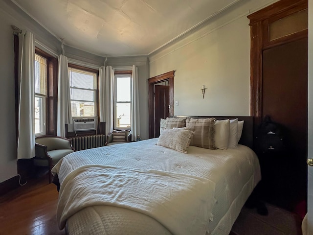 bedroom with radiator, cooling unit, hardwood / wood-style flooring, and ornamental molding