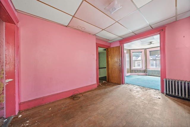 152 Bidwell Ave, Jersey City, NJ 07305 - empty room with radiator heating unit, a drop ceiling, and hardwood / wood-style flooring