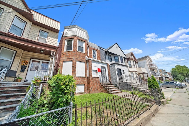 152 Bidwell Ave, Jersey City, NJ 07305 - view of property featuring a fenced front yard, a residential view, brick siding, and a porch