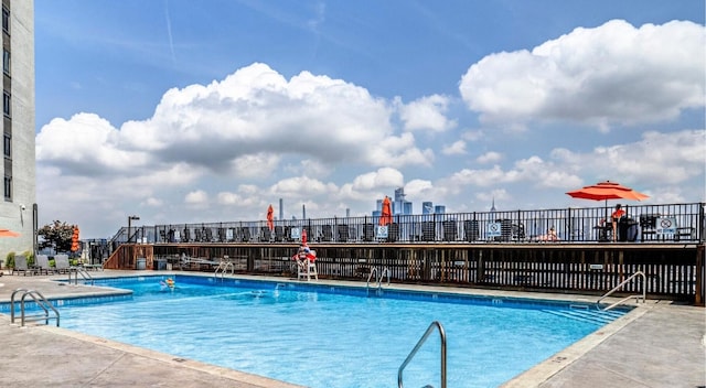 community pool featuring fence and a patio area