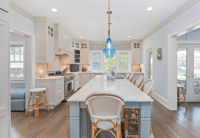 26 Bridge St, Bay Head Borough, NJ 08742 - kitchen with high end stove, dark wood-style floors, backsplash, ornamental molding, and a kitchen breakfast bar