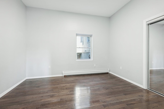 unfurnished room with a baseboard radiator, wood finished floors, and baseboards