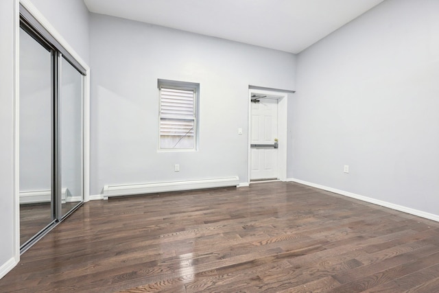 unfurnished bedroom with a baseboard radiator, a closet, baseboards, and wood finished floors