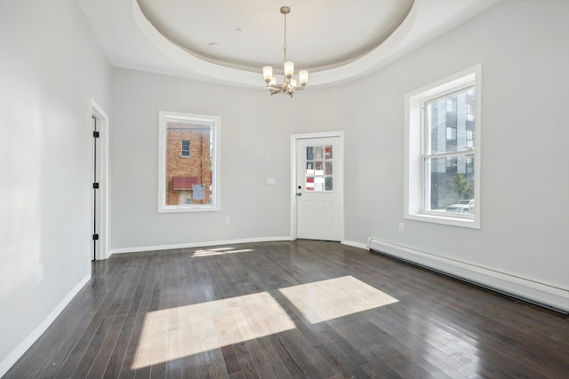 interior space featuring a baseboard heating unit, a raised ceiling, wood-type flooring, and baseboards