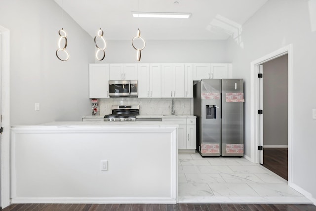 kitchen with marble finish floor, stainless steel appliances, light countertops, and white cabinetry