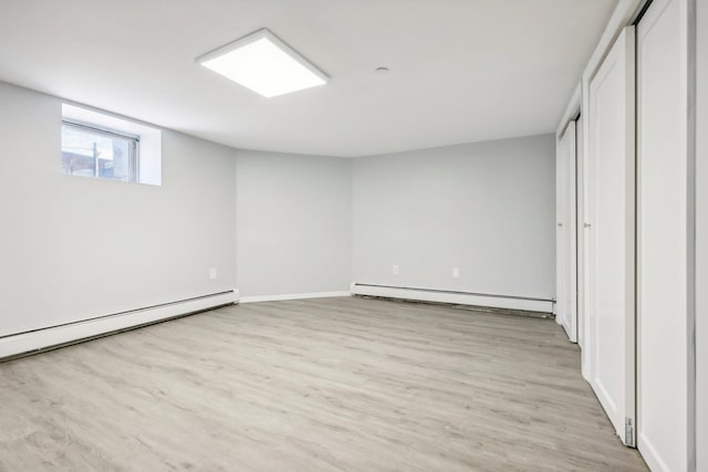 interior space with light wood-type flooring and baseboard heating