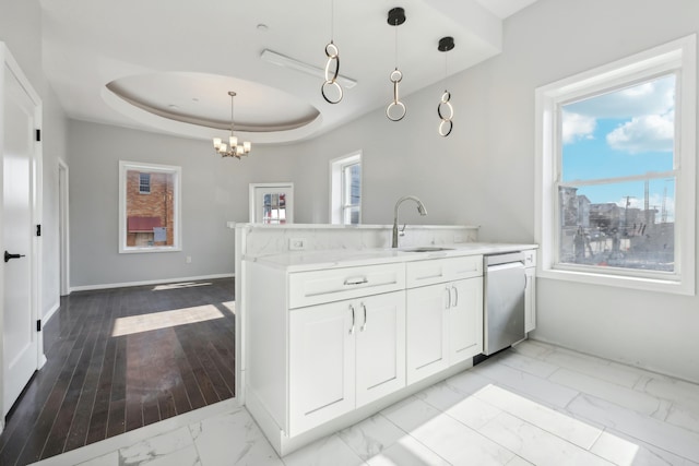 kitchen with marble finish floor, a raised ceiling, white cabinets, a sink, and dishwasher