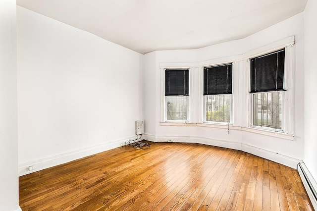 268 Bergen Ave, Jersey City, NJ 07305 - unfurnished room featuring a baseboard heating unit, wood-type flooring, and baseboards