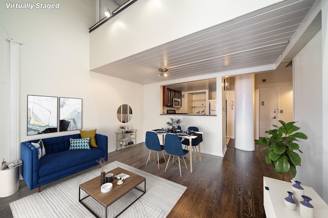 living room with wooden ceiling, baseboards, and wood finished floors