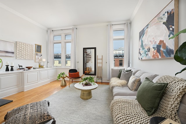 living area featuring a wealth of natural light, crown molding, and wood finished floors