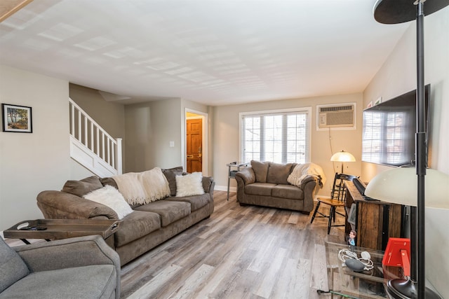 104 W 52nd St, Bayonne, NJ 07002 - living room featuring wood finished floors, an AC wall unit, stairs, and a healthy amount of sunlight