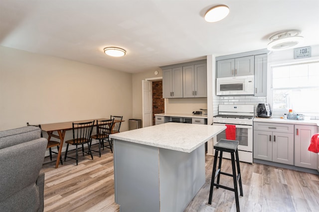 104 W 52nd St, Bayonne, NJ 07002 - kitchen featuring light wood-type flooring, gray cabinets, and white appliances