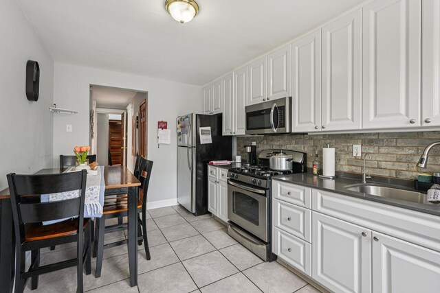 6607 Kennedy Blvd, North Bergen, NJ 07047 - kitchen featuring appliances with stainless steel finishes, tasteful backsplash, and white cabinetry