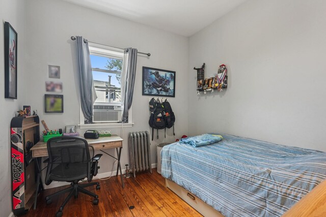 6607 Kennedy Blvd, North Bergen, NJ 07047 - bedroom with radiator heating unit, wood-type flooring, and cooling unit