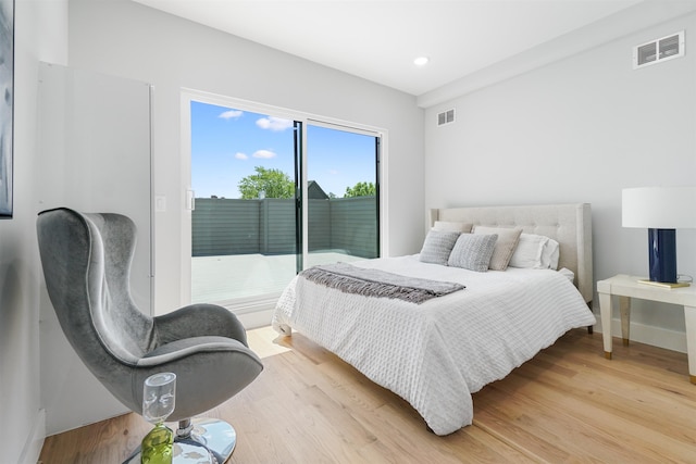 bedroom with access to outside and hardwood / wood-style floors