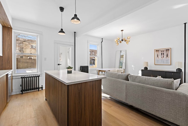 living area with light wood-type flooring, radiator, and a notable chandelier