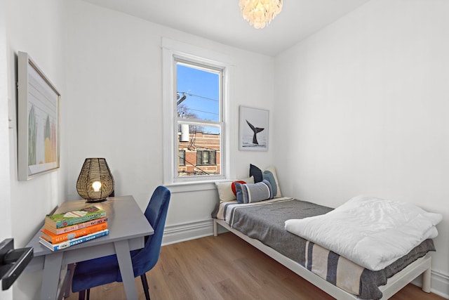 bedroom featuring wood finished floors and a chandelier