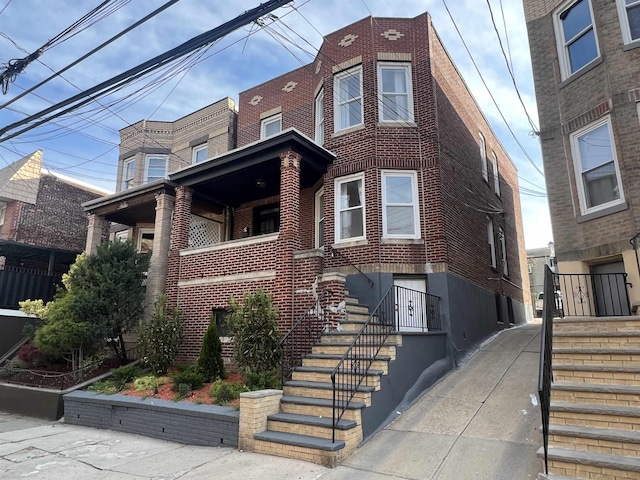 view of front of house with stairs and brick siding