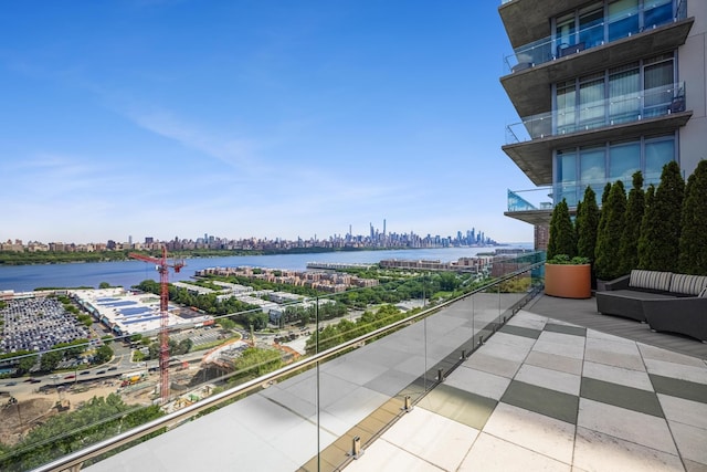 balcony with an outdoor living space and a water view