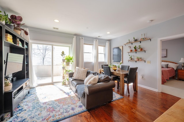 living room with visible vents, recessed lighting, baseboards, and wood finished floors