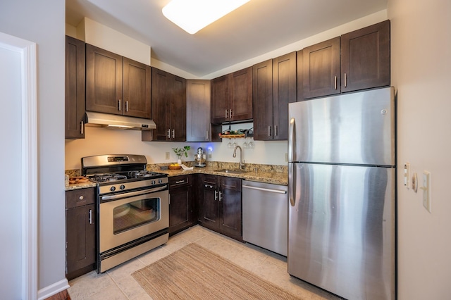 kitchen featuring a sink, dark brown cabinetry, under cabinet range hood, and stainless steel appliances