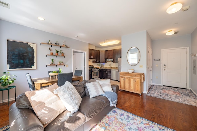 living area featuring recessed lighting, dark wood-style floors, visible vents, and baseboards