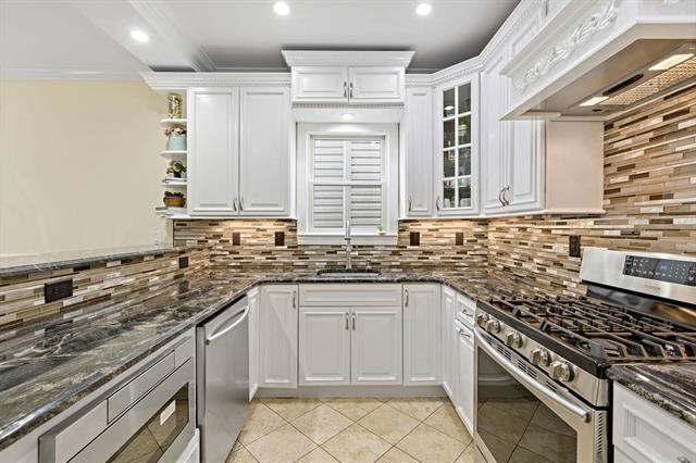 15 Nelson Ave Unit 1, Jersey City, NJ 07307 - kitchen with appliances with stainless steel finishes, extractor fan, light tile patterned floors, white cabinetry, and ornamental molding
